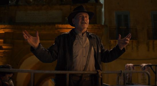 Harrison Ford gesturing with his arms as he speaks in a nighttime scene in Indiana Jones and the Dial of Destiny.
