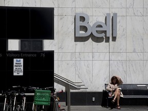 Une femme lisant devant un bureau de Bell Canada à Toronto.