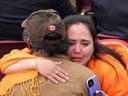 Une femme autochtone pleure en étreignant un être cher alors que le pape François prend la parole lors d'un événement public à Iqaluit lors de sa visite en juillet 2022. Près de la moitié des Canadiens blâment l'Église catholique pour le traumatisme des pensionnats.