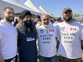 Jasraj Singh Hallan, député de Calgary Forest Lawn, deuxième à partir de la gauche, est représenté debout avec Mahmoud Mourra, deuxième à droite, et deux autres hommes.  L'image a été tirée d'une page Facebook publiée par Mourra.  Le bureau du chef conservateur Pierre Poilievre reste discret sur un député de premier plan posant pour la photo avec deux personnes portant des chemises portant un message opposé à l'enseignement du sexe et du genre dans les écoles.