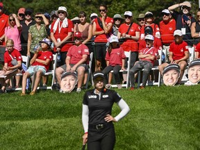 Les fans de Brooke Henderson la regardent se tenir sur le green.