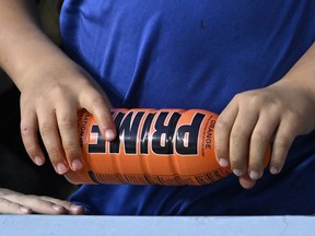 Un enfant tient une boisson hydratante PRIME avant un match de baseball