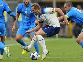 DOSSIER - L'Anglais Harry Kane, au centre, portant un brassard arc-en-ciel, contrôle le ballon lors du match de football de l'UEFA Nations League entre l'Italie et l'Angleterre au stade San Siro, à Milan, en Italie, le 23 septembre 2022. L'anti-discrimination "One Love" Le brassard de capitaine controversé refusé aux équipes lors de la Coupe du monde masculine au Qatar sera porté lors de la Coupe du monde féminine le mois prochain dans une version modifiée désormais approuvée par la FIFA.  La FIFA a dévoilé huit brassards de campagne le vendredi 30 juin 2023.