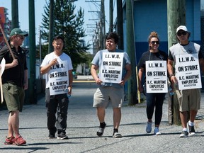 La fin de semaine dernière, des travailleurs portuaires en grève appartenant à l'International Longshore and Warehouse Union Canada marchent sur la ligne de piquetage près de l'entrée Clark Drive du port de Vancouver.