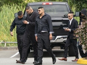 Allie Grewal, alias Ali Grewal, des amis des Hells Angels, assiste à son service funéraire à Delta, en Colombie-Britannique, le 16 août 2019. Harb Dhaliwal est au milieu, les bras tendus vers le bas, et à droite, portant également des lunettes de soleil, est accusé tueur Tyrel Nguyen Quesnelle.