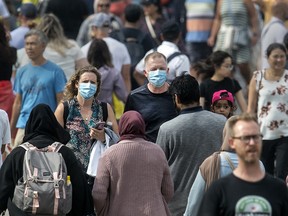 Deux personnes portant des masques en marchant dans une foule.