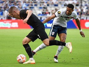 Le milieu de terrain canadien Liam Fraser (à gauche) se bat pour le ballon avec le défenseur cubain Mario Penalver