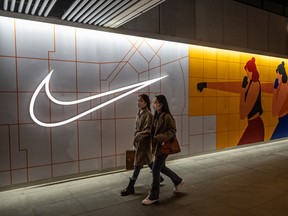 Des femmes passent devant un magasin Nike à Pékin, en Chine.