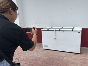 Un journaliste thaïlandais prend une photo d'un congélateur vide au poste de police de Nong Prue à Pattaya, province de Chonburi, Thaïlande, le mardi 11 juillet 2023.