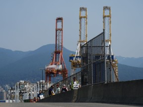 Les travailleurs en grève de l'International Longshore and Warehouse Union Canada piquent à l'entrée d'un port à Vancouver, en Colombie-Britannique, le mardi 4 juillet 2023. Les ports de la Colombie-Britannique font face à un avenir incertain après que le syndicat des débardeurs a rejeté un accord de médiation provisoire et a repris la grève qui avait été temporairement interrompue la semaine dernière seulement.