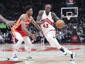 L'attaquant des Raptors de Toronto Pascal Siakam contrôle le ballon alors que l'attaquant des Hawks d'Atlanta De'Andre Hunter tente de défendre.