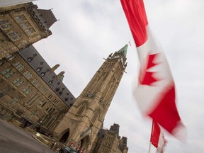 Un drapeau canadien flotte devant la Tour de la Paix sur la Colline du Parlement à Ottawa.