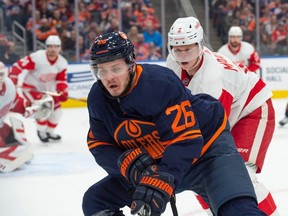 Mattias Janmark (26 ans) des Oilers d'Edmonton, est poursuivi dans le coin par Olli Maatta des Red Wings de Detroit, à Rogers Place à Edmonton, le 15 février 2023.