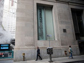 Des piétons passent devant une succursale de Charles Schwab Corp. à New York.