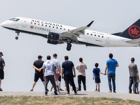 Les gens regardent un avion d'Air Canada décoller.