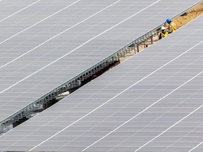 Des ouvriers de la construction achèvent presque les panneaux solaires recouvrant le stationnement de Telus Spark le 14 mars 2022.