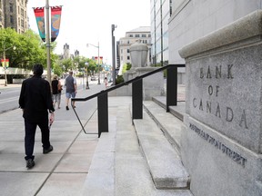 Des piétons passent devant la Banque du Canada à Ottawa.