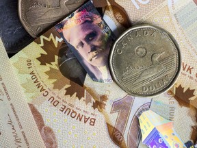 Pièces d'un dollar canadien et billets de cent dollars