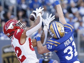 Evan Holm (31 ans) des Blue Bombers renverse la passe de touché destinée à Rysen John des Stampeders, mais il est appelé pour interférence de passe à IG Field hier soir.