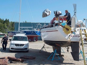 Des agents de l'Agence des services frontaliers du Canada retirent des matériaux gorgés d'eau du voilier Quesera à East River Marine à Hubbards, en Nouvelle-Écosse, le 8 septembre 2017. Environ 250 kilogrammes de cocaïne présumée ont été trouvés sur le navire et deux hommes ont été arrêtés.