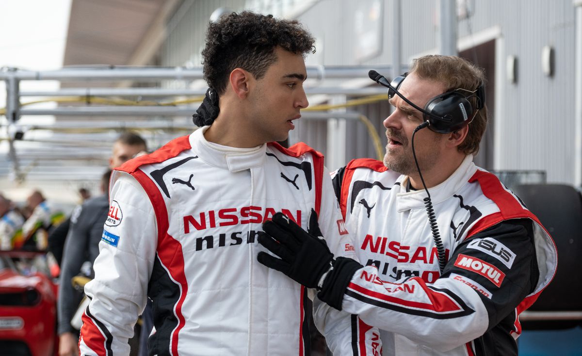 L'ingénieur de course de David Harbour, Jack Salter, rassure le pilote automobile Jann Mardenboroguh (Archie Madekwe), tous deux portant des combinaisons de course Nissan, dans Gran Turismo