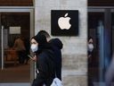 Les acheteurs passent devant un magasin Apple Inc. à Berlin, en Allemagne.