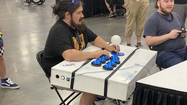 An EVO 2023 attendee with a massively oversized fightstick.