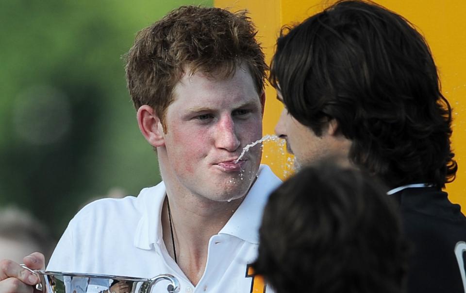 Le prince Harry crache joyeusement du champagne à Nacho Figueras après avoir participé à la deuxième édition annuelle de la Veuve Clicquot Manhattan Polo Classic en 2009 sur Governors Island lors du dernier événement d'une visite de deux jours à New York.