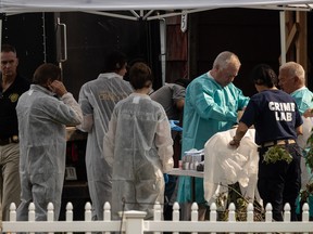 Des agents du laboratoire du crime se préparent à fouiller la maison du suspect des meurtres de Gilgo Beach, Rex Heuermann