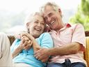 Couple plus âgé avec les bras enroulés l'un autour de l'autre et souriant