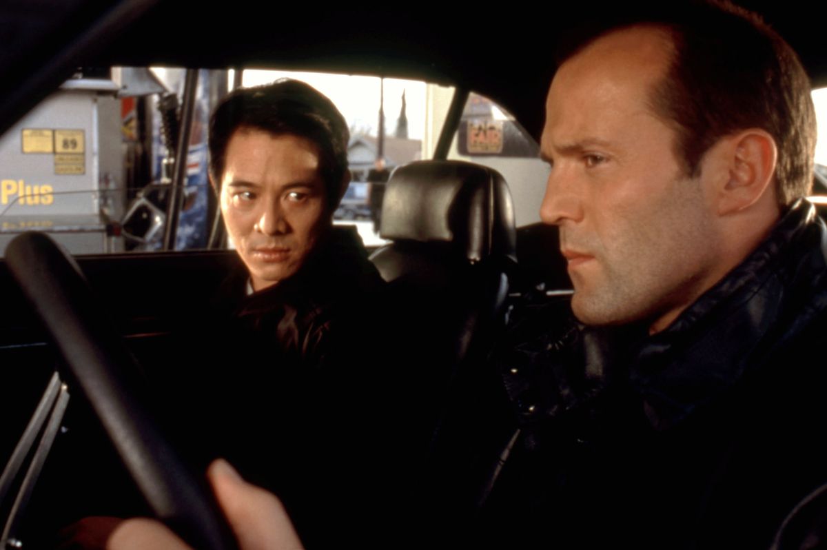 Jet Li et Jason Statham sont assis ensemble dans une voiture.  Li, assis sur le siège passager, regarde Statham (qui a des cheveux), qui est sur le siège du conducteur, dans The One.