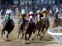 Le vainqueur du Derby du Manitoba, Oil Money, au centre, avec Orlando Mojica, est en tête au premier virage à Assiniboia Downs en mai.