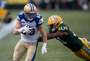 Dalton Schoen (83) des Blue Bombers de Winnipeg casse un tacle d'Ed Gainey (11) des Elks d'Edmonton pendant la première moitié de l'action de la CFL à Edmonton.