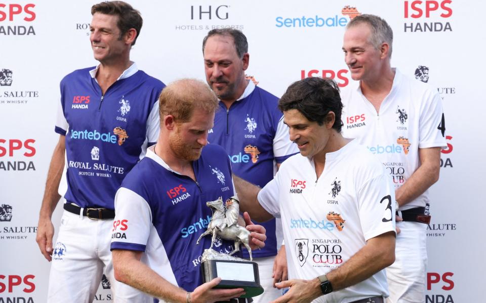 Le Prince et son ami Nacho Figueras reçoivent un trophée après le match