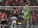 Le gardien de but du Real Madrid Andriy Lunin, à droite, dégage le ballon lors du match de football espagnol de la Liga entre l'Athletic Club et le Real Madrid au stade San Mames de Bilbao, en Espagne, le samedi 12 août 2023.