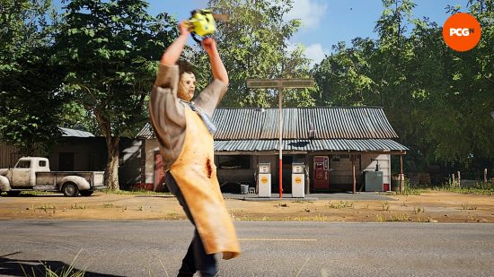 Examen du jeu Texas Chain Saw Massacre: Leatherface tient sa tronçonneuse au-dessus de sa tête avec colère, alors qu'il se tient devant la station-service, un camion Chevy blanc cassé garé à l'extérieur. 