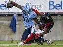 Le receveur éloigné des Argonauts DaVaris Daniels (à gauche) atteint la zone des buts pour un touché alors que le demi défensif des Rouge et Noir Abdul Kanneh défend à Toronto hier soir. 