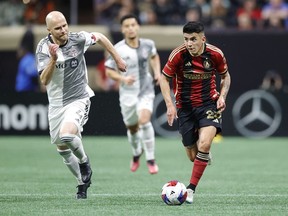 Le milieu de terrain d'Atlanta United Thiago Almada, à droite, passe devant le milieu de terrain du Toronto FC Michael Bradley, à gauche, lors de la seconde moitié d'un match de football de la MLS, le samedi 4 mars 2023, à Atlanta.