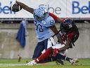 Le receveur éloigné des Argonauts DaVaris Daniels (à gauche) atteint la zone des buts pour un touché alors que le demi défensif des Rouge et Noir Abdul Kanneh défend à Toronto hier soir. 