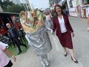 La première ministre de l'Alberta, Danielle Smith, marche parmi les tentes à Taste of Edmonton le jeudi 20 juillet 2023, accompagnée d'une personne portant un costume de donair similaire à celui actuellement mis aux enchères par le gouvernement de l'Alberta sur son site Web d'enchères de surplus. 