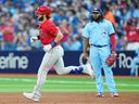 Bryce Harper des Phillies de Philadelphie fait le tour des buts après avoir frappé un circuit en solo sous le regard du joueur de premier but des Blue Jays de Toronto Vladimir Guerrero Jr. lors de la troisième manche le mercredi 16 août 2023 au Rogers Centre. 