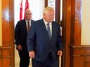 Le premier ministre de l'Ontario, Doug Ford, à droite, suivi du ministre des Affaires municipales et du Logement, Steve Clark, quittent une conférence de presse à la suite de la publication du rapport spécial du vérificateur général sur les modifications apportées à la Ceinture de verdure, à Queens Park, à Toronto, le 9 août 2023.