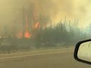 Un véhicule circule sur l'autoroute alors que des personnes évacuent de Yellowknife, dans les Territoires du Nord-Ouest, en raison d'un incendie de forêt qui approche, le 16 août 2023.