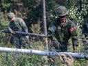 Des soldats des Forces armées canadiennes construisent un coupe-feu dans le Parker Recreation Field à Yellowknife pour aider à lutter contre les incendies de forêt le mercredi 16 août 2023. 