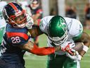 Tyrice Beverette (26 ans) des Alouettes de Montréal s'attaque à Tevin Jones (14 ans) des Roughriders de la Saskatchewan lors d'un match de football de la LCF en deuxième mi-temps à Montréal, le vendredi 11 août 2023.