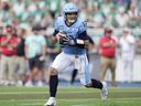 Le quart-arrière des Argonauts de Toronto, Chad Kelly, court avec le ballon lors d'un match de la LCF contre les Roughriders de la Saskatchewan.