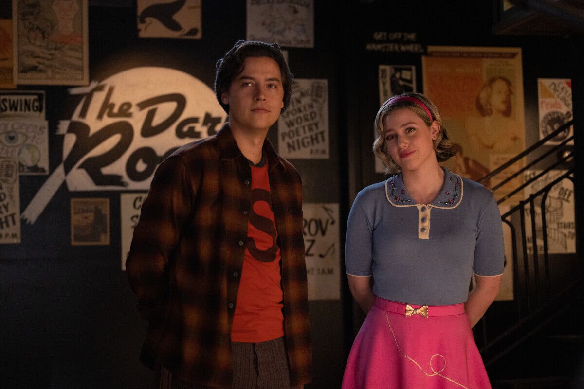 Jughead (Cole Sprouse) et Betty (Lili Reinhart) debout et souriant à moitié à quelque chose 