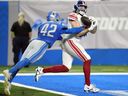 L'ailier rapproché des Giants de New York Tommy Sweeney, défendu par le secondeur des Lions de Détroit Jalen Reeves-Maybin (42 ans), capte une passe de 14 verges pour un touché lors de la première moitié d'un match de football préparatoire de la NFL, le vendredi 11 août 2023, à Détroit.