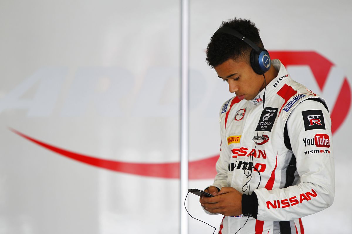 Jann Mardenborough écoute de la musique dans un uniforme de course Nissan/Nismo en 2014