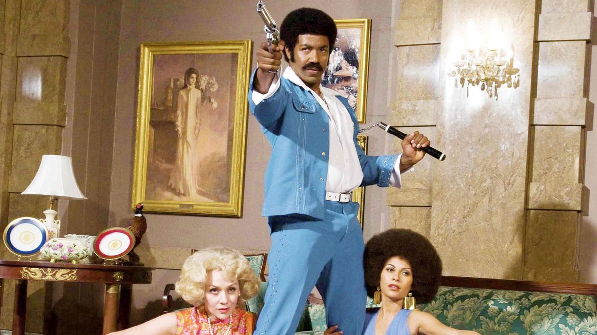 Black Dynamite posant avec un pistolet et des nunchucks.